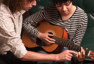 teach student to play guitar